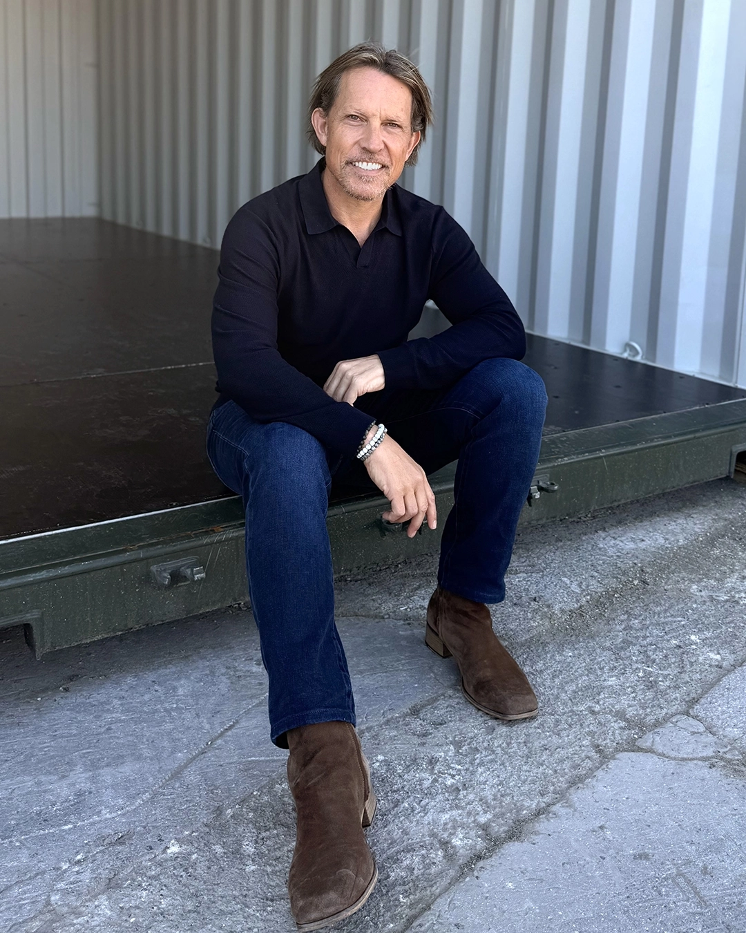Portrait of Peter Whitehead sitting in shipping container storage in Croydon